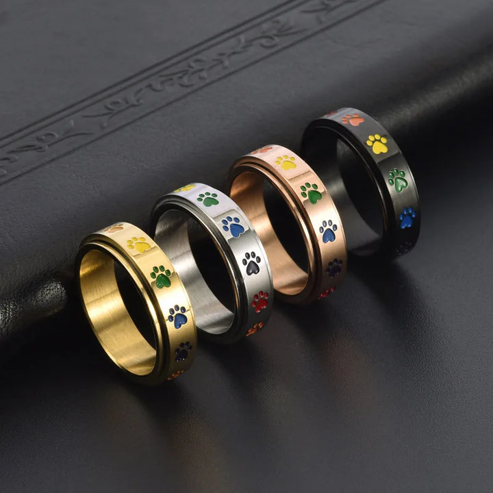 Rotating stress-reducing paw ring - stainless steel with rainbow paws