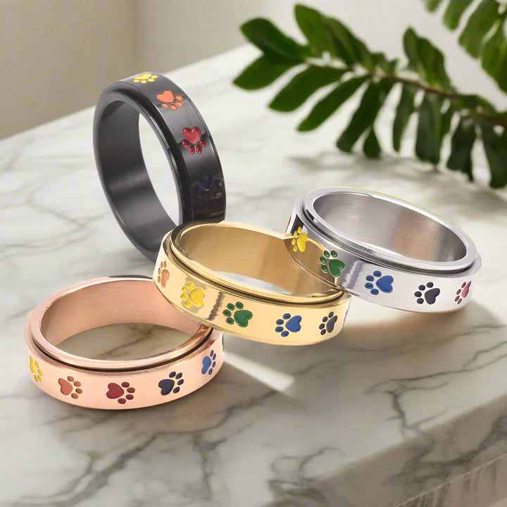 Rotating stress-reducing paw ring - stainless steel with rainbow paws