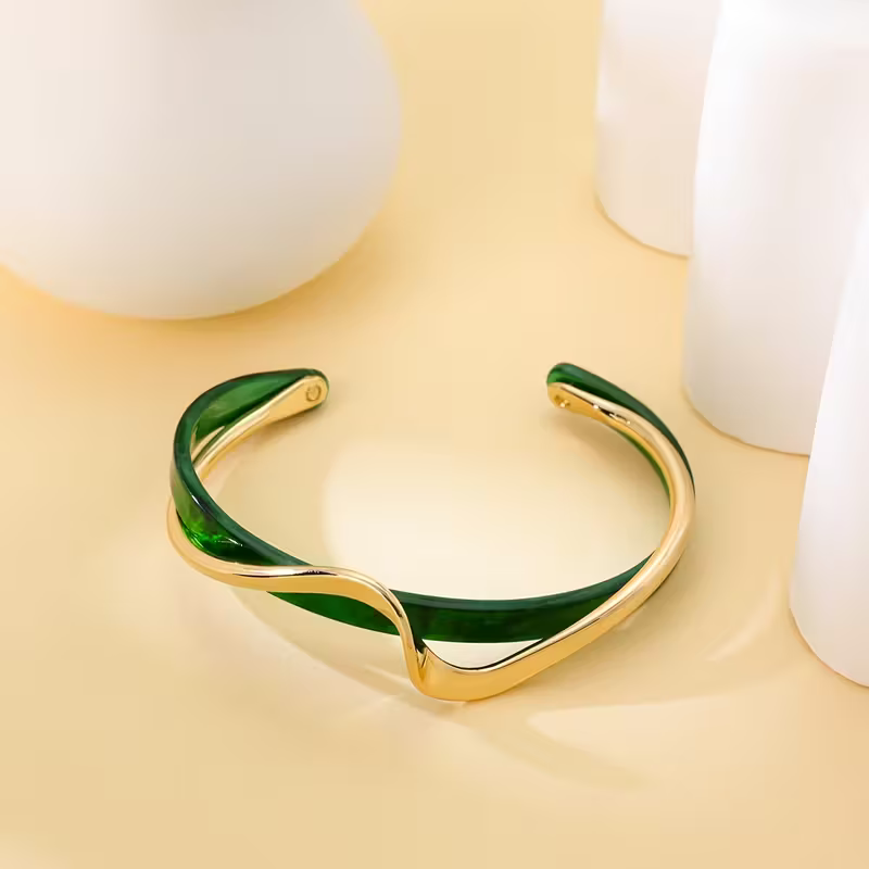 Elegant Gold and Emerald Wave Bracelet