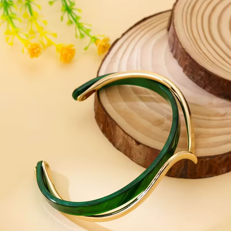 Elegant Gold and Emerald Wave Bracelet