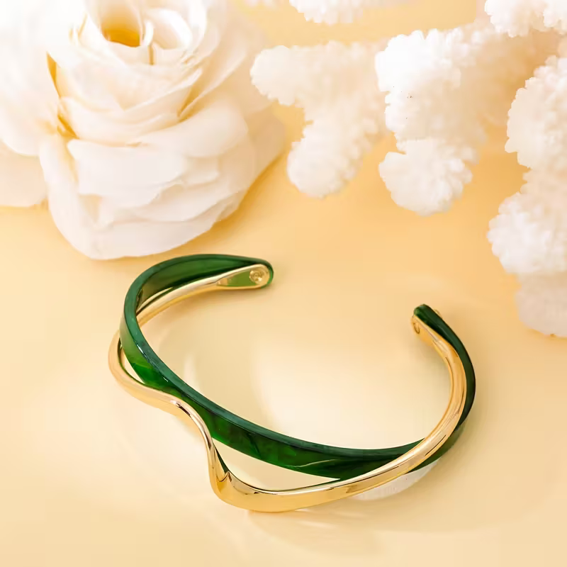 Elegant Gold and Emerald Wave Bracelet
